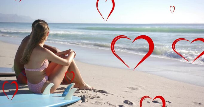 Animation of red hearts over diverse couple in love on beach in summer