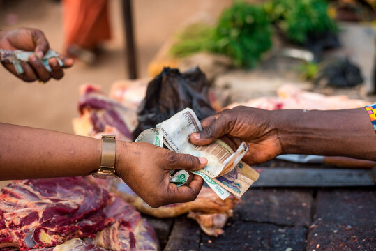 A woman pays for meat with naira notes at Bodija Market in Oyo, Nigeria on Monday, February 19, 2024.