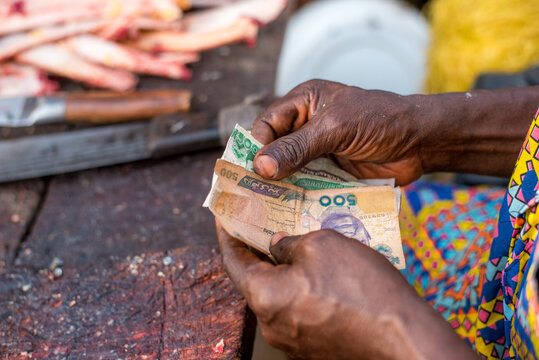 A man counts naira notes received as payment for meat at Bodija Market in Oyo, Nigeria on Monday, February 19, 2024. 