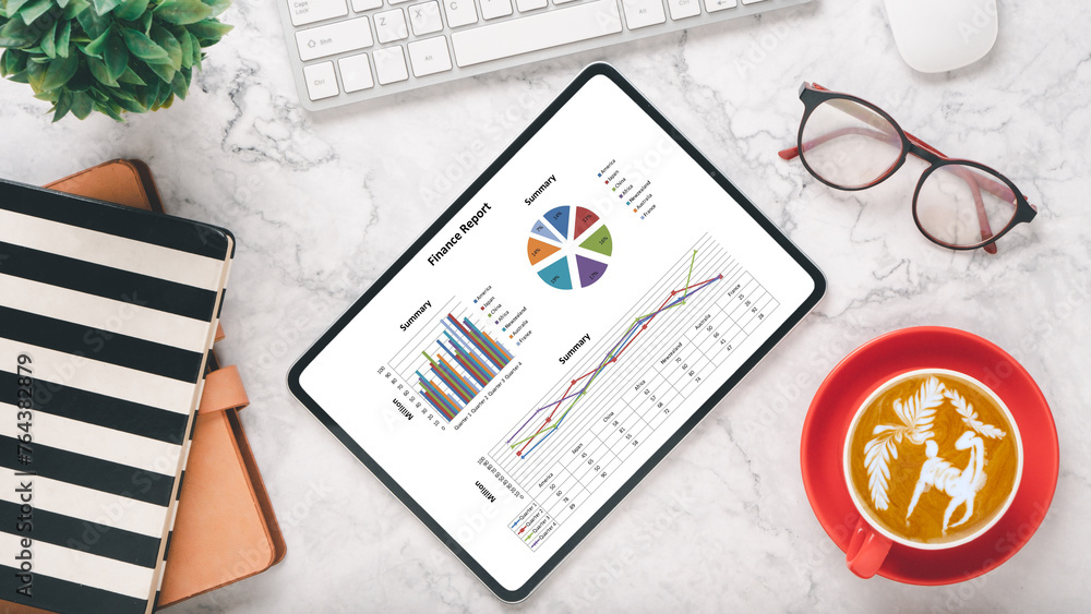 Poster elegant office setting with a tablet displaying colorful financial charts, alongside a notepad, glas