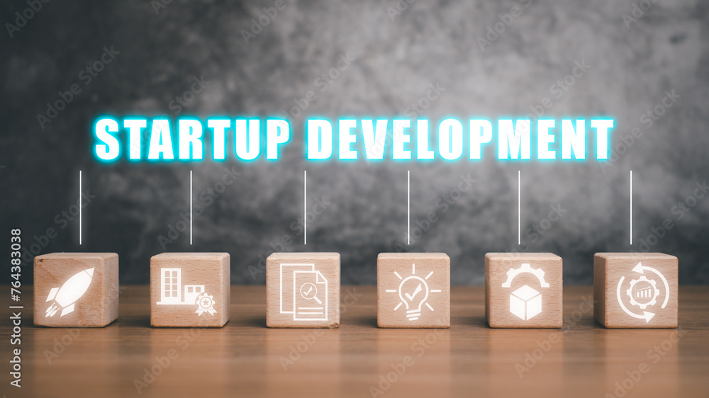 Poster startup development concept, wooden block on desk with startup development icon non virtual screen.