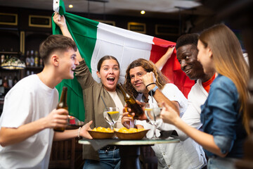 Joyful fans of the Italian team celebrating the victory in the night bar