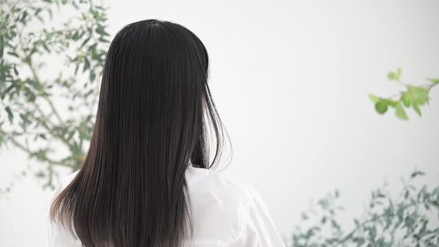 オーガニックでナチュラルなイメージの若い女性の髪をかき上げるしぐさの動画