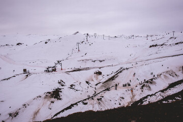 Joyous winter moments: ski lift and playful little silhouettes against the clear snow in a beautiful hilltop view
