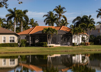 Typical concrete house on the shore of a lake in southwest Florida in the countryside with palm...