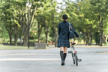 公園の中を自転車を押して歩く制服姿の中学生・高校生・女子高生
公園の中を自転車を押して歩く制服姿の中学生・高校生・女子高生
