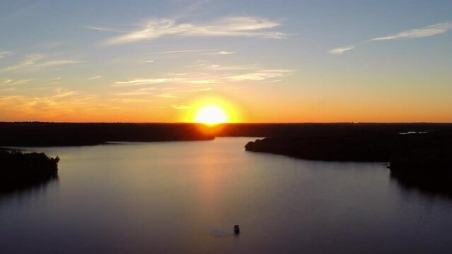 Aerial Downward Shot Of Nautical Vessel Moving On Rippled River During Sunset - Buckner, California
