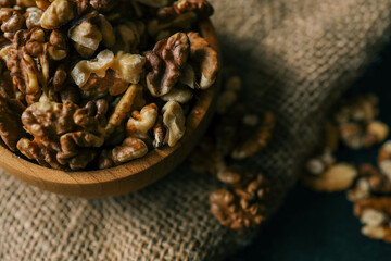 Walnuts in a wooden plate on a dark background