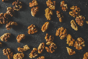 Walnuts in a wooden spoon on a black background