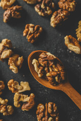 Walnuts in a wooden spoon on a black background
