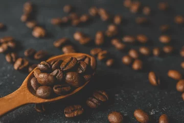 Badkamer foto achterwand Coffee beans pour out from a wooden spoon on a retro background, top view © shine.graphics