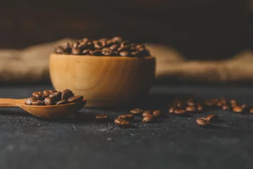 Tuinposter Coffee beans in a wooden plate on a black background © shine.graphics