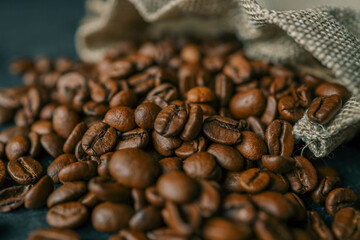 Coffee beans in a wooden plate on a black background