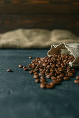 Coffee beans in a wooden plate on a black background