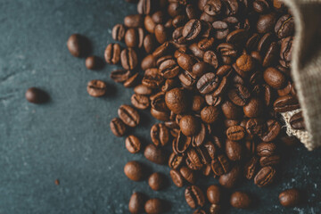Coffee beans in a wooden plate on a black background