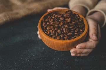 Fotobehang Coffee beans in a wooden plate on a black background © shine.graphics