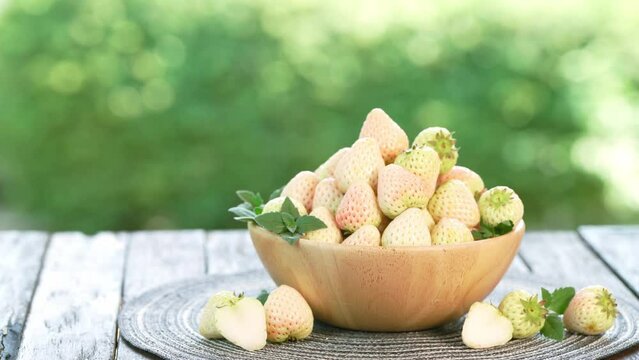 Pink snow Strawberries on wooden Background, Pink snow strawberry on green bokeh background.