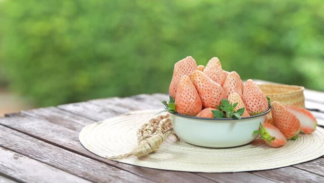 Pink snow Strawberries on wooden Background, Pink snow strawberry on green bokeh background.