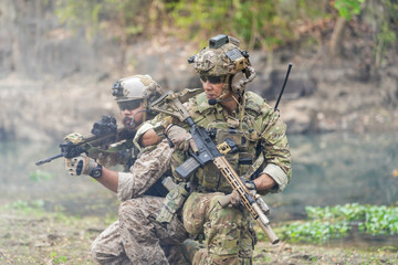Fototapeta premium Soldiers in tactical gear aiming guns during a military exercise, showcasing teamwork and defense strategies.