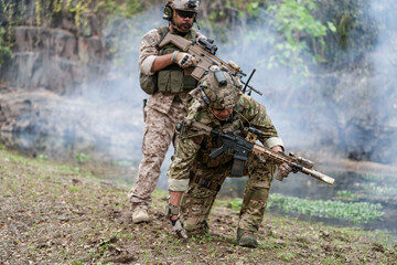 Soldiers in tactical gear aiming guns during a military exercise, showcasing teamwork and defense...
