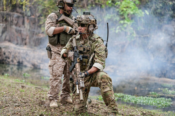 Fototapeta premium Soldiers in tactical gear aiming guns during a military exercise, showcasing teamwork and defense strategies.