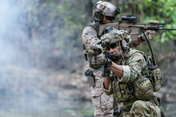 Fototapeta premium Soldiers in tactical gear aiming guns during a military exercise, showcasing teamwork and defense strategies.