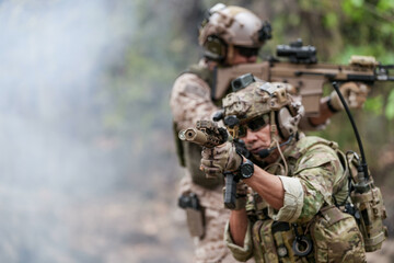 Fototapeta premium Soldiers in tactical gear aiming guns during a military exercise, showcasing teamwork and defense strategies.