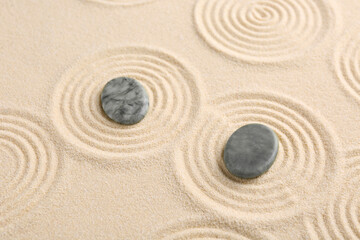 Zen garden stones on beige sand with pattern