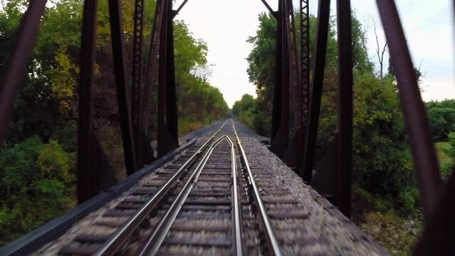 Aerial: Drone Forward Shot Of Railroad Track On Truss Bridge Amidst Green Trees - Buckner, California