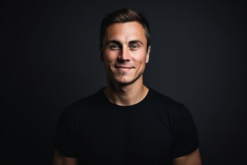 Portrait of a handsome young man in a black t-shirt - obrazy, fototapety, plakaty