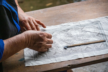 A Flower Hmong woman draws a pattern for her traditional embroidery, Mu Cang Chai, Yen Bai, Vietnam - obrazy, fototapety, plakaty