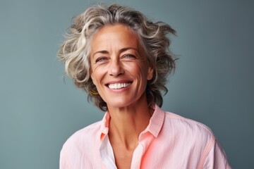 Portrait of a happy senior woman smiling at the camera over blue background