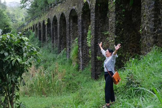 Woman standing alone in wild nature, spreading her hands enjoying her freedom