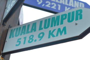 Close-up shots of directional signs pointing towards the enchanting destinations of the Kuala Lumpur