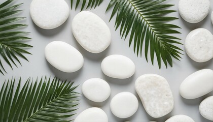 Elegant arrangement of white stones and palm leaves on a pristine background, viewed from above, perfect for a luxury spa or tropical summer product display - 764437237
