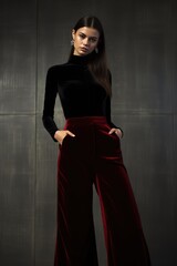 Naklejka premium A velvet bodysuit paired with wide-leg trousers for a sleek and modern holiday ensemble. Woman fashion christmas.