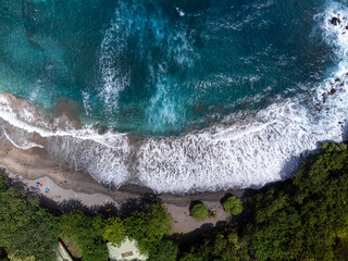 A top down Aerial photo of Crystal clear Turquoise water and waves meeting with a tropical beach....