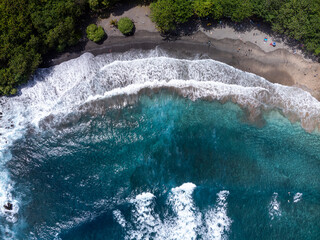 A top down Aerial photo of Crystal clear Turquoise water and waves meeting with a tropical beach....