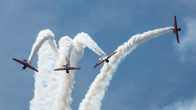 formation flight of T-6 texans perform inverted with smoke traiking from their exhaust