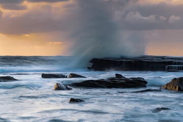 Moody sunrise seascape with clouds at the rocky inlet