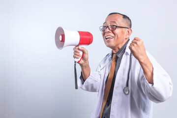 Excited senior Asian doctor wear glasses, clenching fist and holding megaphones announces good...