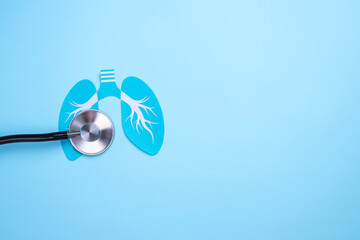 Paper lungs and stethoscope on blue background with copy space
