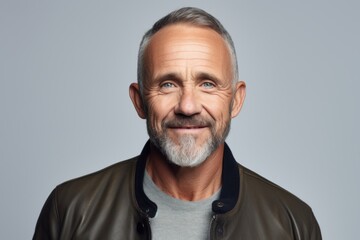 Happy mature man in leather jacket. Isolated on grey background.