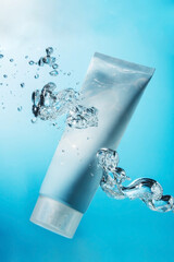 Cream tube in blue water with bubbles in the tank. Copy space. moisturizing cosmetic concept