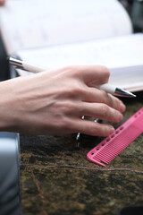 Young european successful employee business woman writing in notebook diary sit work at wooden office desk