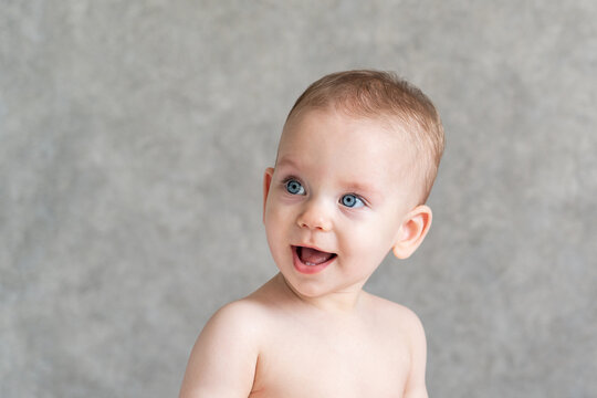 A joyfully surprised baby turns around at the sound and looks attentively