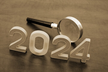 Experts analytics for year 2024. Magnifying glass and numbers 2024 on table.	
