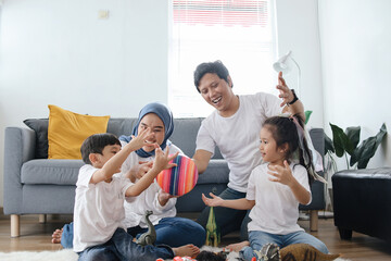 Parents with Two Kids Playing Toys Together at Living Room. Happy Family Bonding at Home.  - obrazy, fototapety, plakaty