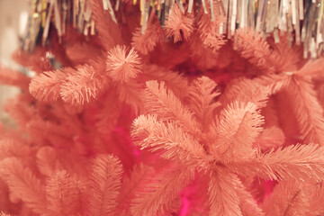 Close up of pink Christmas tree with metallic tinsel glitter rain, background with copy space....