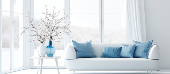An elegant white couch is accessorized with lovely blue pillows and a vase housing a small tree on display